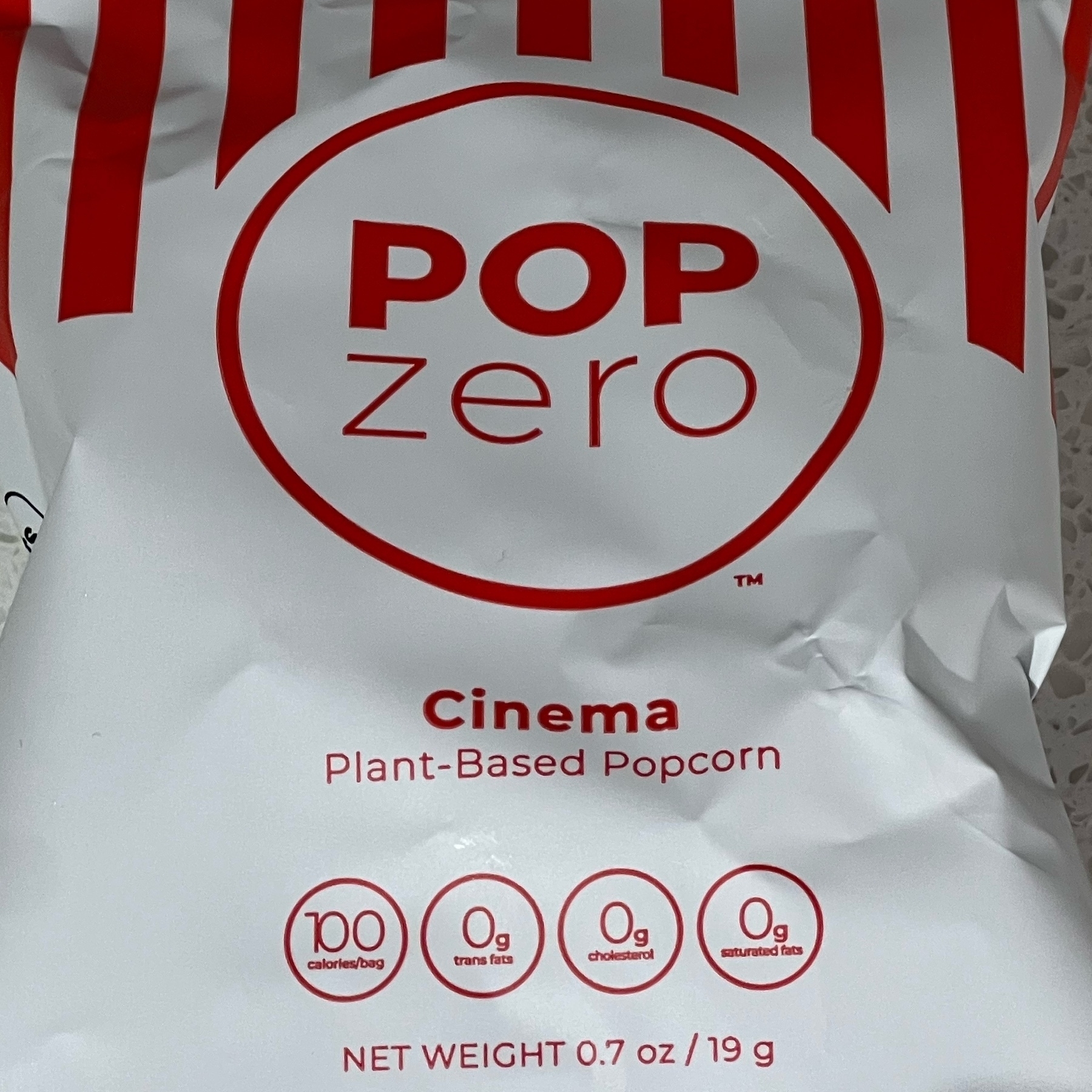red and white bag of pop zero popcorn cinema flavor that says "Plant based"